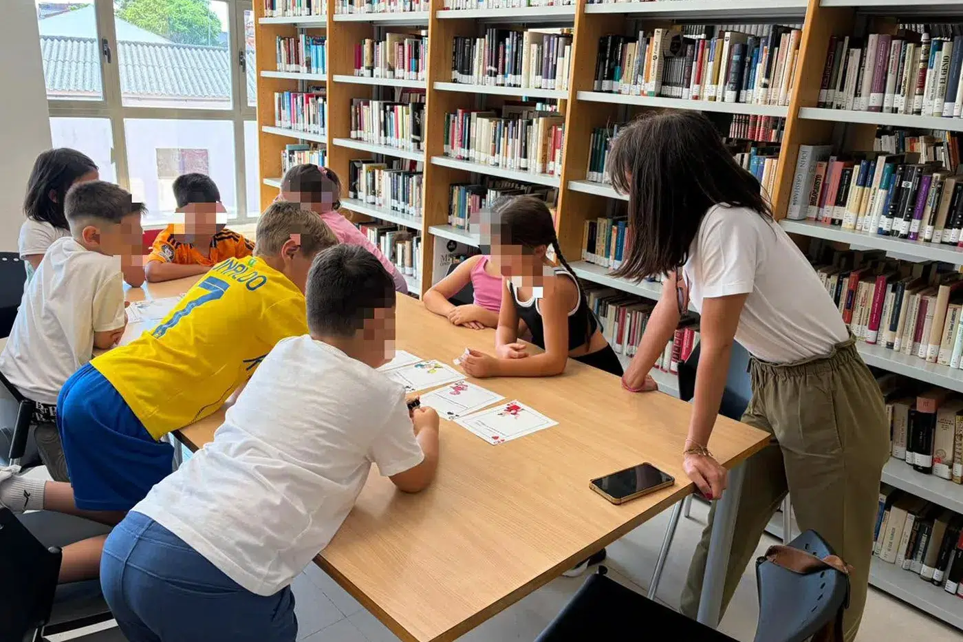 Escolares de Santa Olalla participando en los talleres de fomento de la lectura en las mesas de la biblioteca municipal