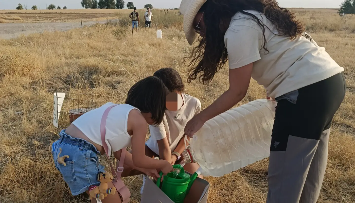 Participantes en la Noche de la Regadera y las Estrellas en Torrijos regando las plantaciones de la Cañada