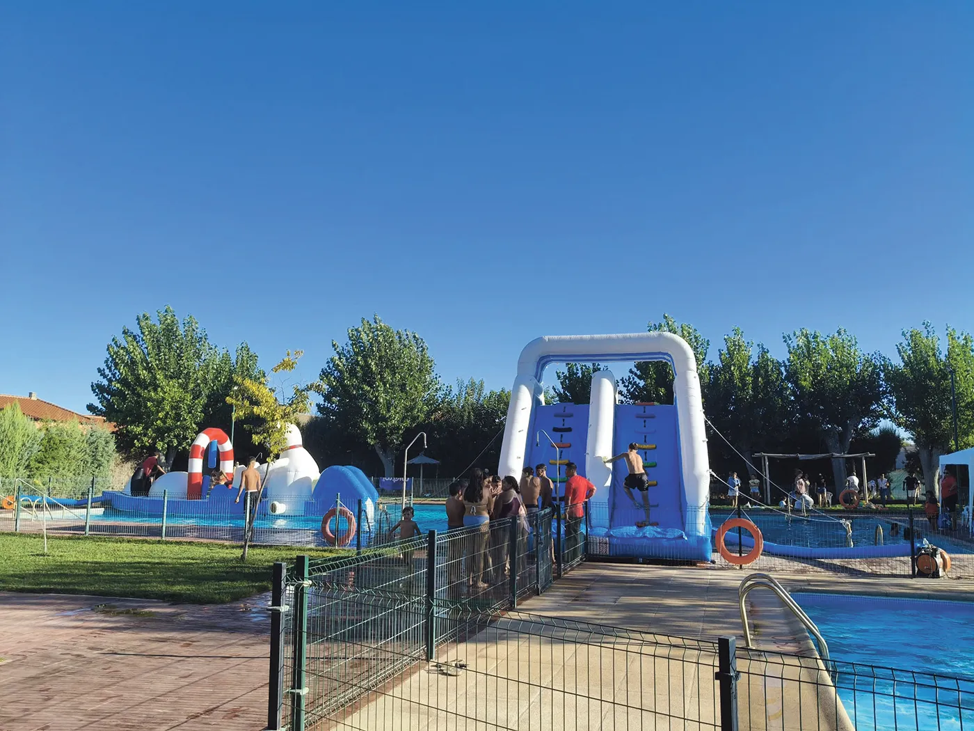 Familias disfrutando de la fiesta acuática en la piscina municipal de Burujón.